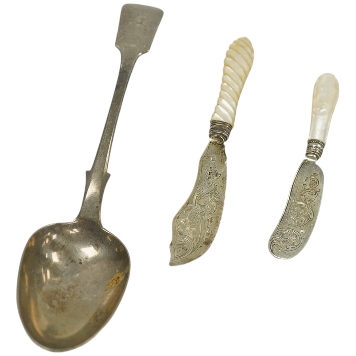 Two Victorian mother of pearl handled butter knives and a Victorian Scottish silver fiddle pattern basting spoon. Condition - fair